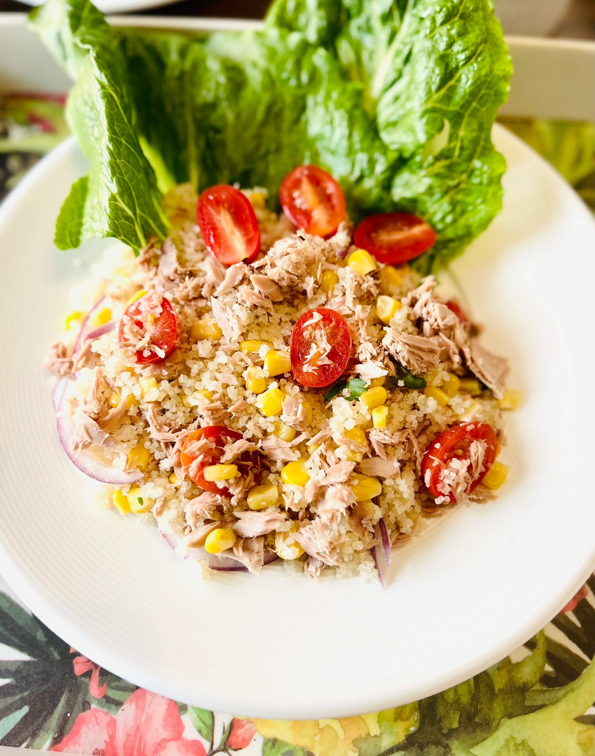 Salade d'attiéké garnie de thon, de légumes frais comme des tomates et des oignons, le tout assaisonné d'une vinaigrette légère. Un plat nutritif et savoureux