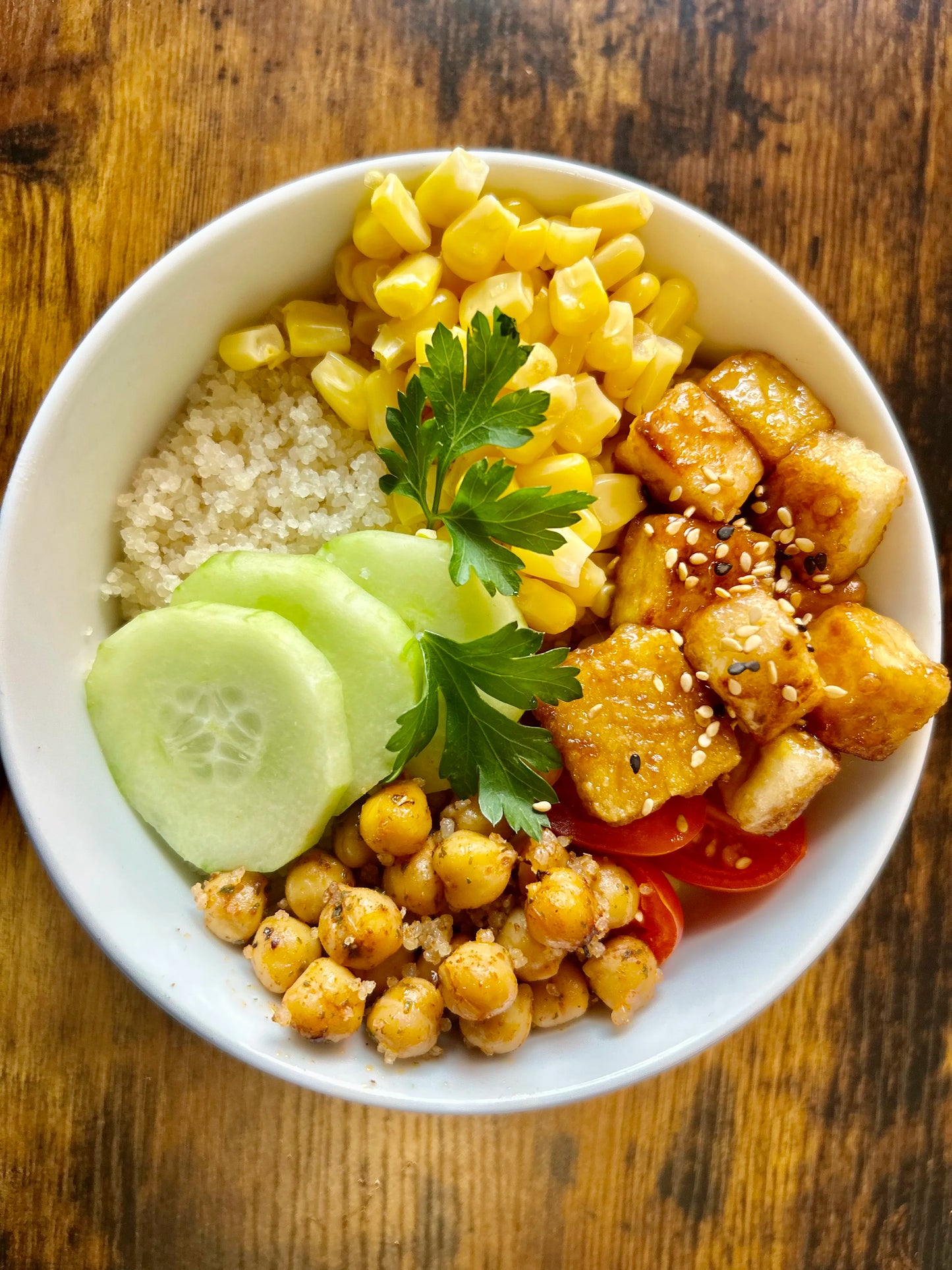 Poké bowl coloré composé d'attiéké, de tofu mariné, de légumes frais comme des avocats et des concombres, le tout servi dans un bol. Un plat sain et savoureux